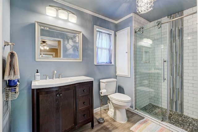 bathroom featuring wood finished floors, a shower stall, toilet, and vanity