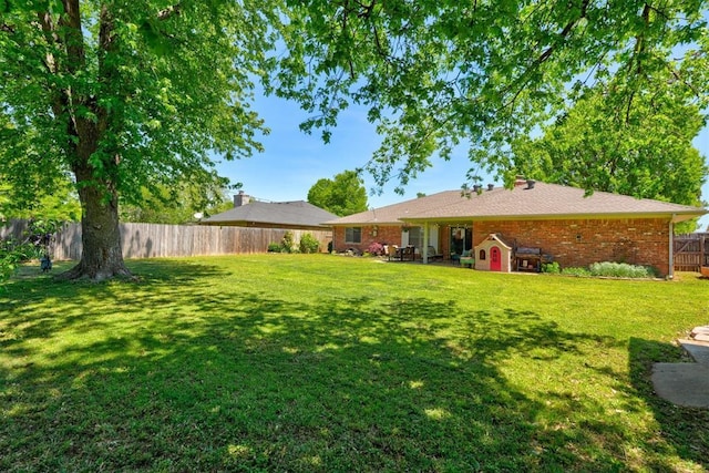 view of yard with a fenced backyard and an outdoor structure