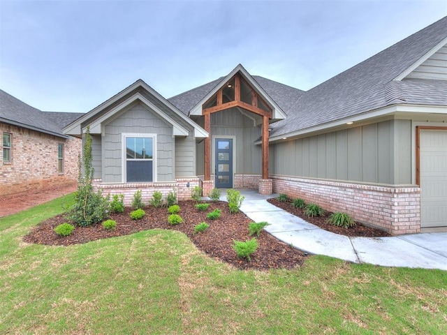 1715 Zayden Ln, Norman, OK 73072 - view of front of house with a front lawn, an attached garage, board and batten siding, and brick siding