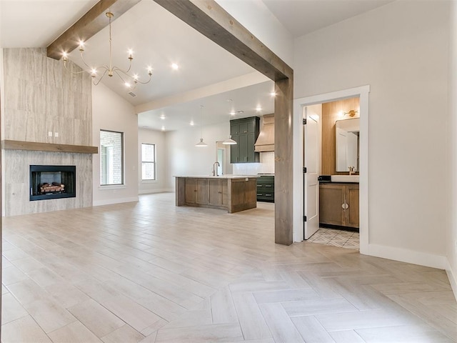 1715 Zayden Ln, Norman, OK 73072 - unfurnished living room with a large fireplace, baseboards, high vaulted ceiling, a notable chandelier, and beam ceiling