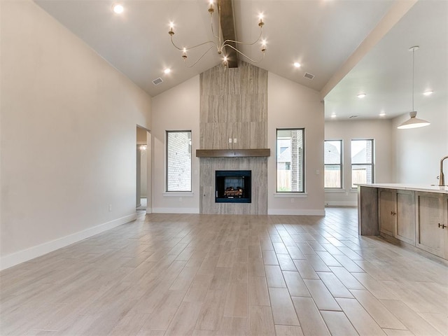 1715 Zayden Ln, Norman, OK 73072 - unfurnished living room with beamed ceiling, light wood finished floors, an inviting chandelier, high vaulted ceiling, and visible vents