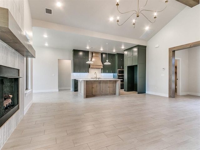 1715 Zayden Ln, Norman, OK 73072 - kitchen featuring a sink, a fireplace, tasteful backsplash, visible vents, and premium range hood