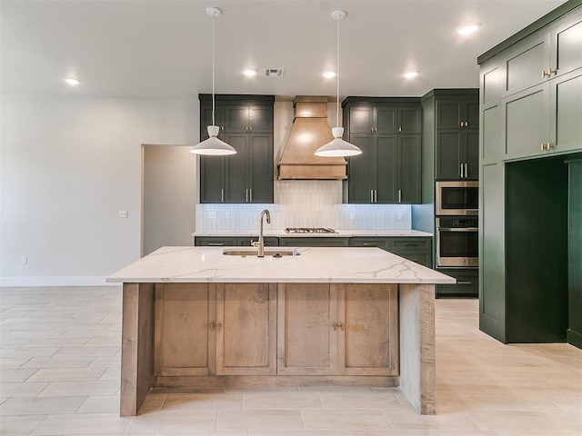 1715 Zayden Ln, Norman, OK 73072 - kitchen with light stone counters, green cabinetry, a sink, appliances with stainless steel finishes, and premium range hood