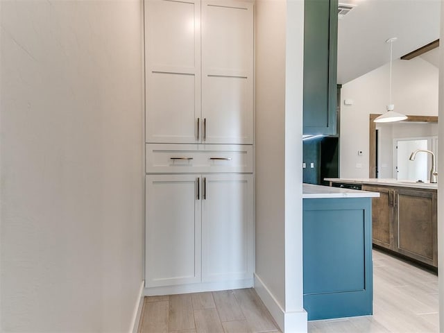 1715 Zayden Ln, Norman, OK 73072 - interior space with decorative light fixtures, light countertops, vaulted ceiling, a sink, and baseboards