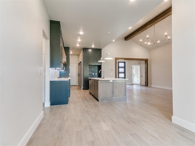 1715 Zayden Ln, Norman, OK 73072 - kitchen featuring lofted ceiling with beams, an island with sink, light countertops, a sink, and baseboards