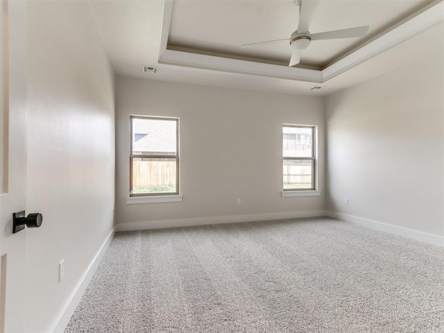 1715 Zayden Ln, Norman, OK 73072 - carpeted spare room featuring visible vents, ceiling fan, a wealth of natural light, and a raised ceiling