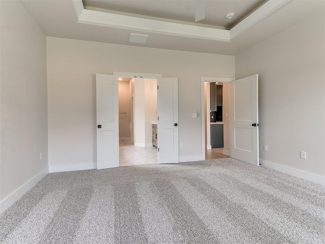 1715 Zayden Ln, Norman, OK 73072 - unfurnished bedroom featuring light colored carpet, a raised ceiling, and baseboards