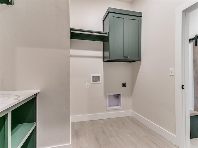 1715 Zayden Ln, Norman, OK 73072 - laundry area featuring light wood finished floors, cabinet space, electric dryer hookup, hookup for a washing machine, and baseboards