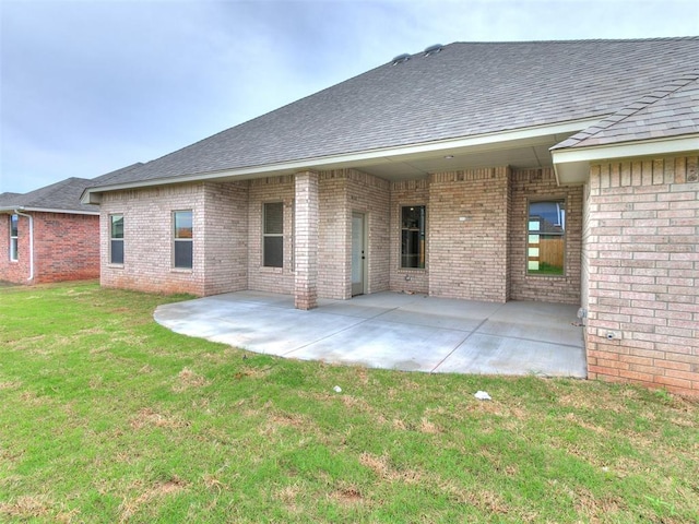 1715 Zayden Ln, Norman, OK 73072 - rear view of house featuring a lawn, a patio, and brick siding