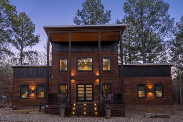 back of house with crawl space and covered porch