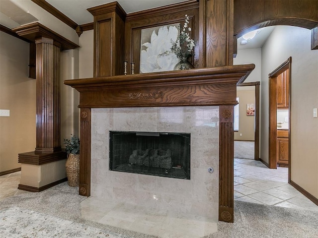 interior details with a high end fireplace, arched walkways, carpet floors, baseboards, and decorative columns
