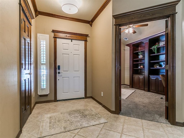 entrance foyer featuring crown molding, baseboards, ceiling fan, and light tile patterned floors
