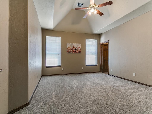 carpeted spare room featuring vaulted ceiling, a ceiling fan, a textured wall, baseboards, and visible vents
