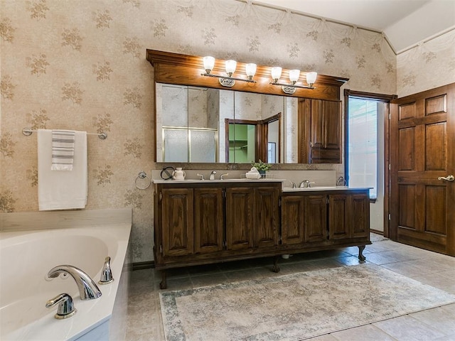 full bath featuring a sink, double vanity, wallpapered walls, tile patterned flooring, and a garden tub