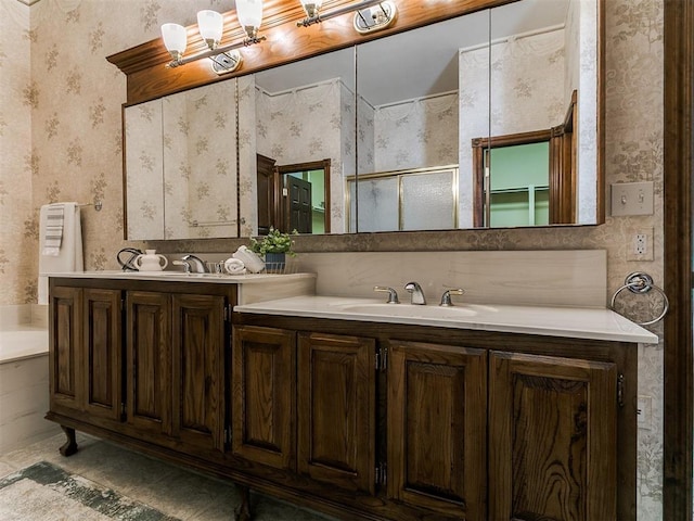 full bath featuring wallpapered walls, vanity, and a stall shower