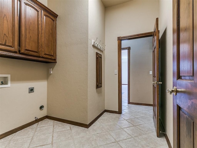 clothes washing area featuring a textured wall, light tile patterned floors, hookup for an electric dryer, cabinet space, and washer hookup