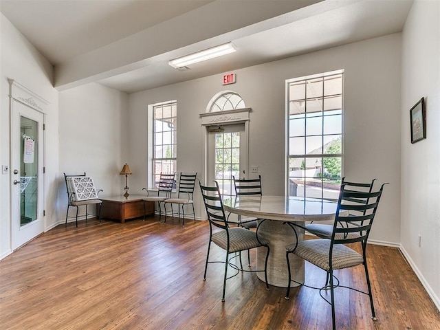 dining space with baseboards and wood finished floors