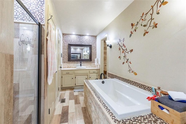 full bath featuring vanity, a stall shower, a garden tub, and visible vents