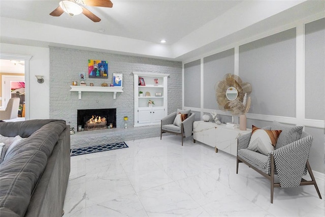 living room with ceiling fan, built in features, a brick fireplace, marble finish floor, and recessed lighting