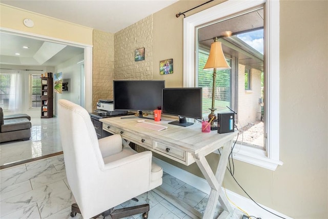 office featuring plenty of natural light, marble finish floor, and baseboards