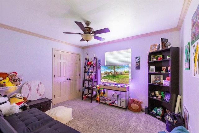recreation room featuring crown molding, a ceiling fan, and carpet flooring