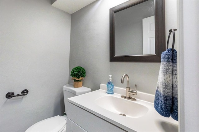 half bathroom with vanity and toilet