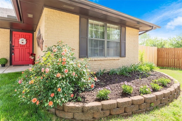 entrance to property with fence and brick siding