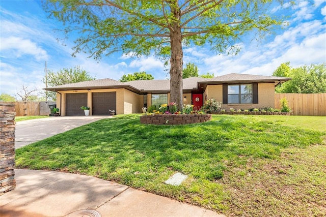 ranch-style home with fence, an attached garage, driveway, and a front yard
