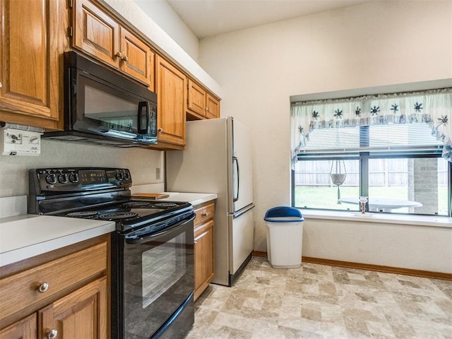 1717 Park View Pl, Edmond, OK 73003 - kitchen featuring black appliances, brown cabinets, baseboards, and light countertops