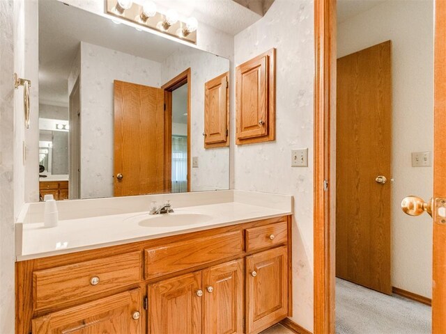 1717 Park View Pl, Edmond, OK 73003 - bathroom featuring vanity, baseboards, and wallpapered walls