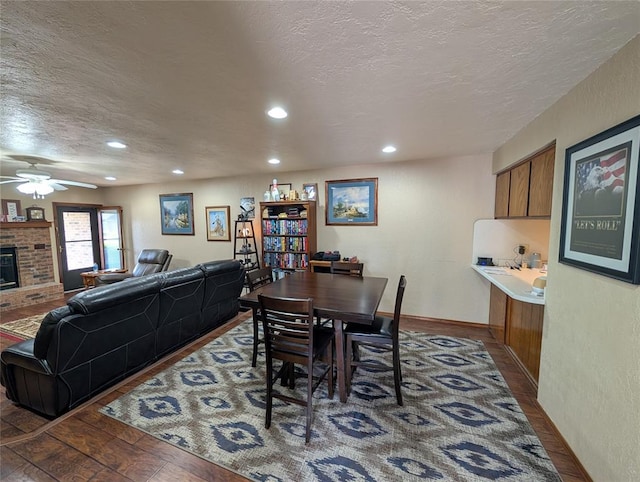 3207 Lois Arlene Cir, Moore, OK 73160 - dining area featuring a textured ceiling, hardwood / wood-style floors, ceiling fan, a fireplace, and recessed lighting