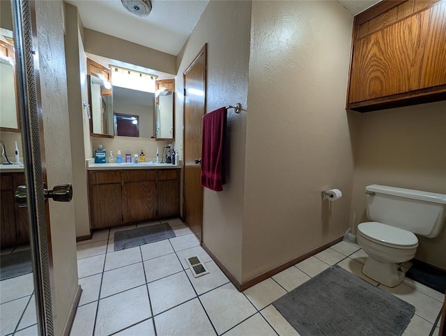 3207 Lois Arlene Cir, Moore, OK 73160 - bathroom featuring tile patterned flooring, a textured wall, toilet, vanity, and baseboards
