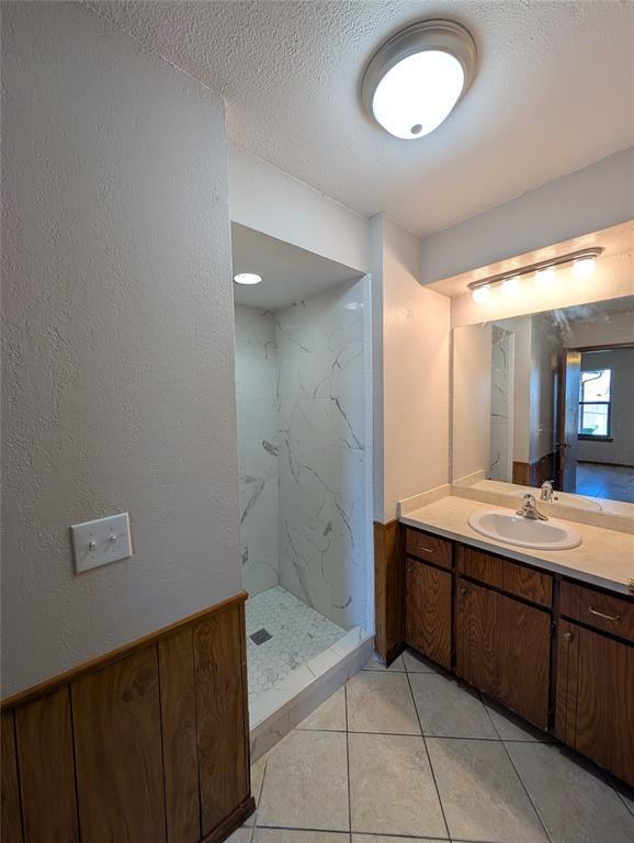 3207 Lois Arlene Cir, Moore, OK 73160 - full bath featuring tile patterned floors, a textured wall, vanity, a marble finish shower, and a textured ceiling