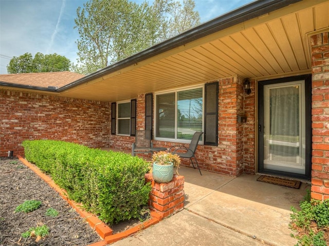 doorway to property featuring brick siding