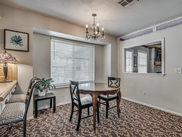 dining room with an inviting chandelier, carpet floors, visible vents, baseboards, and a textured ceiling