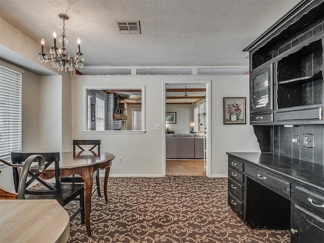 carpeted dining area with a textured ceiling, an inviting chandelier, baseboards, and visible vents