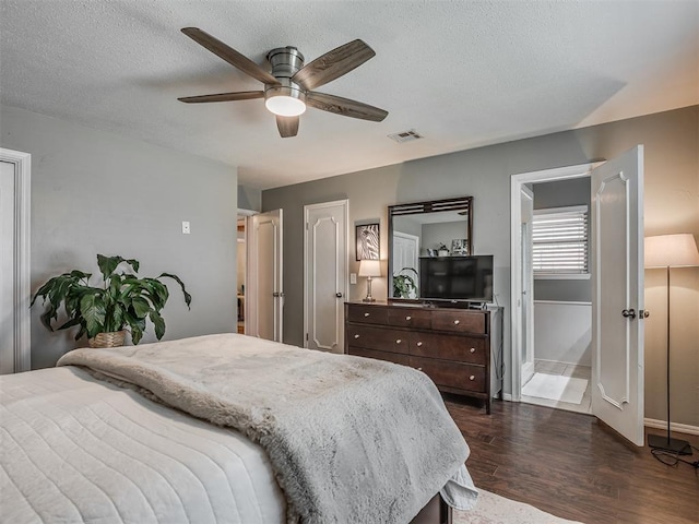 bedroom featuring ceiling fan, a textured ceiling, visible vents, dark wood finished floors, and baseboards