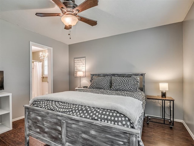 bedroom featuring baseboards, wood finished floors, ceiling fan with notable chandelier, and ensuite bath