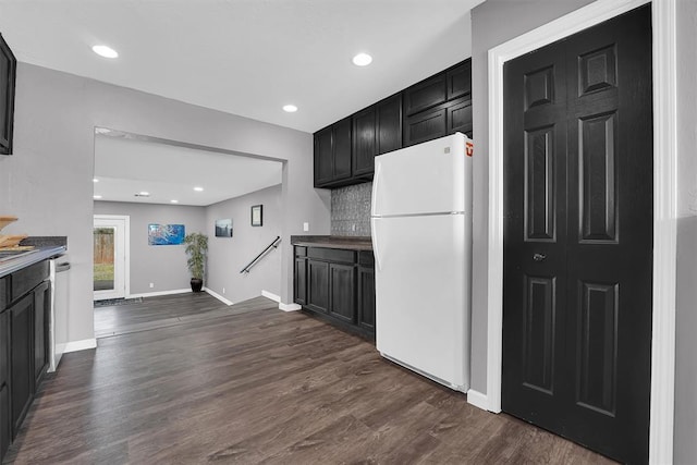 113 Central Dr, Sayre, OK 73662 - kitchen with decorative backsplash, baseboards, dark wood-style floors, and freestanding refrigerator