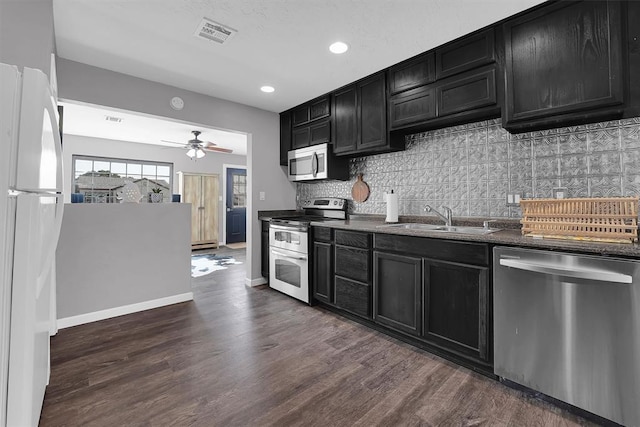 113 Central Dr, Sayre, OK 73662 - kitchen with stainless steel appliances, a sink, tasteful backsplash, visible vents, and dark cabinets