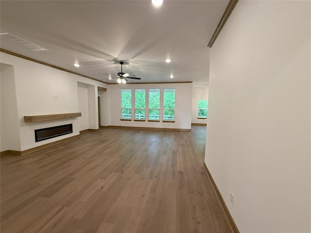 unfurnished living room featuring a glass covered fireplace, recessed lighting, visible vents, and baseboards