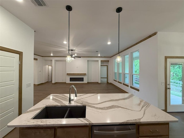 kitchen featuring a sink, visible vents, open floor plan, dishwasher, and a kitchen island with sink