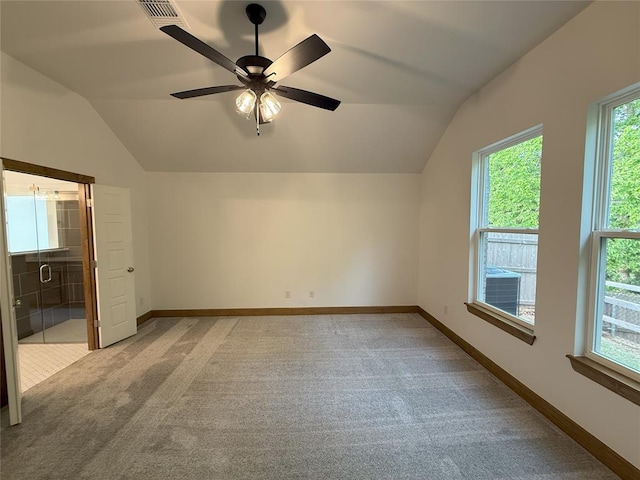 unfurnished bedroom featuring light colored carpet, vaulted ceiling, baseboards, visible vents, and a ceiling fan