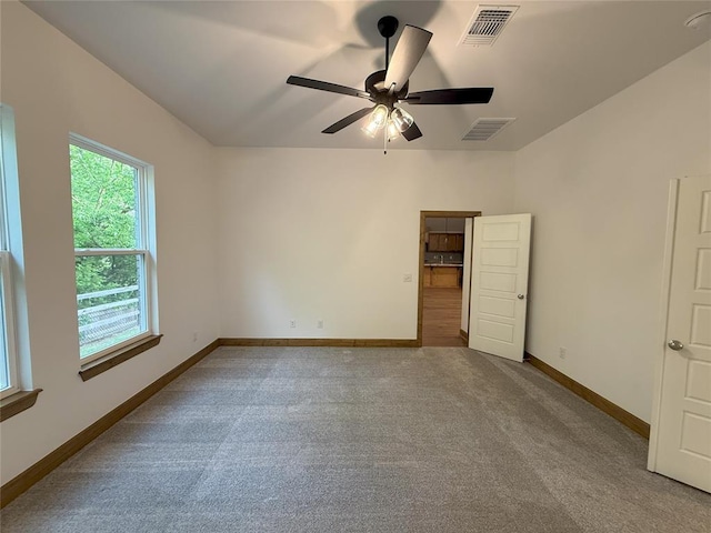 interior space with visible vents, baseboards, a ceiling fan, and carpet floors