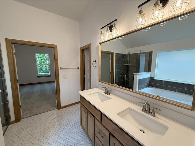 bathroom with baseboards, a shower stall, double vanity, and a sink