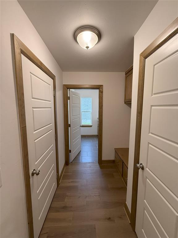 hallway with baseboards and dark wood-style flooring
