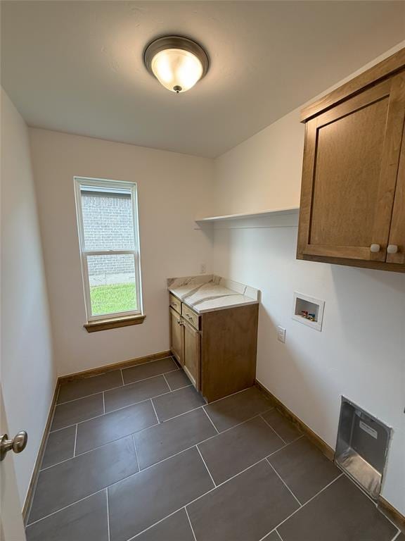 washroom with washer hookup, dark tile patterned flooring, cabinet space, and baseboards
