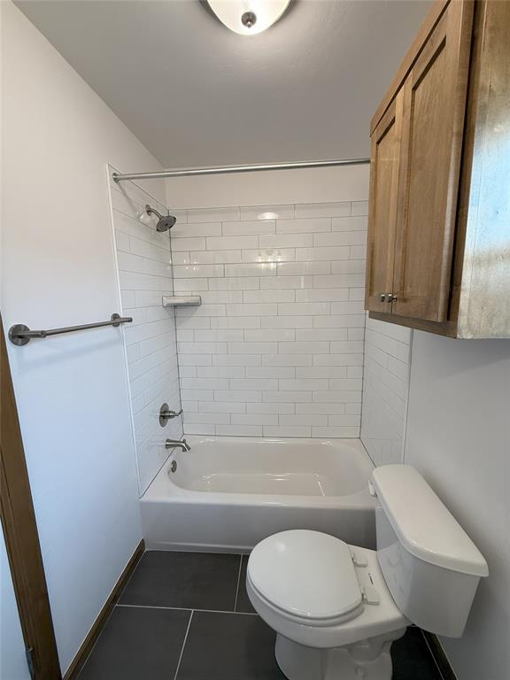 bathroom with toilet, shower / bathtub combination, and tile patterned flooring