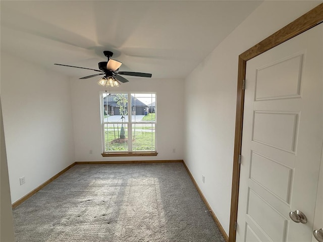 carpeted spare room with baseboards and ceiling fan