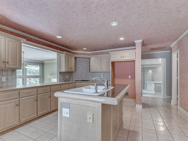 13504 Fox Creek Dr, Oklahoma City, OK 73131 - kitchen with light tile patterned floors, ornamental molding, a center island with sink, backsplash, and a sink